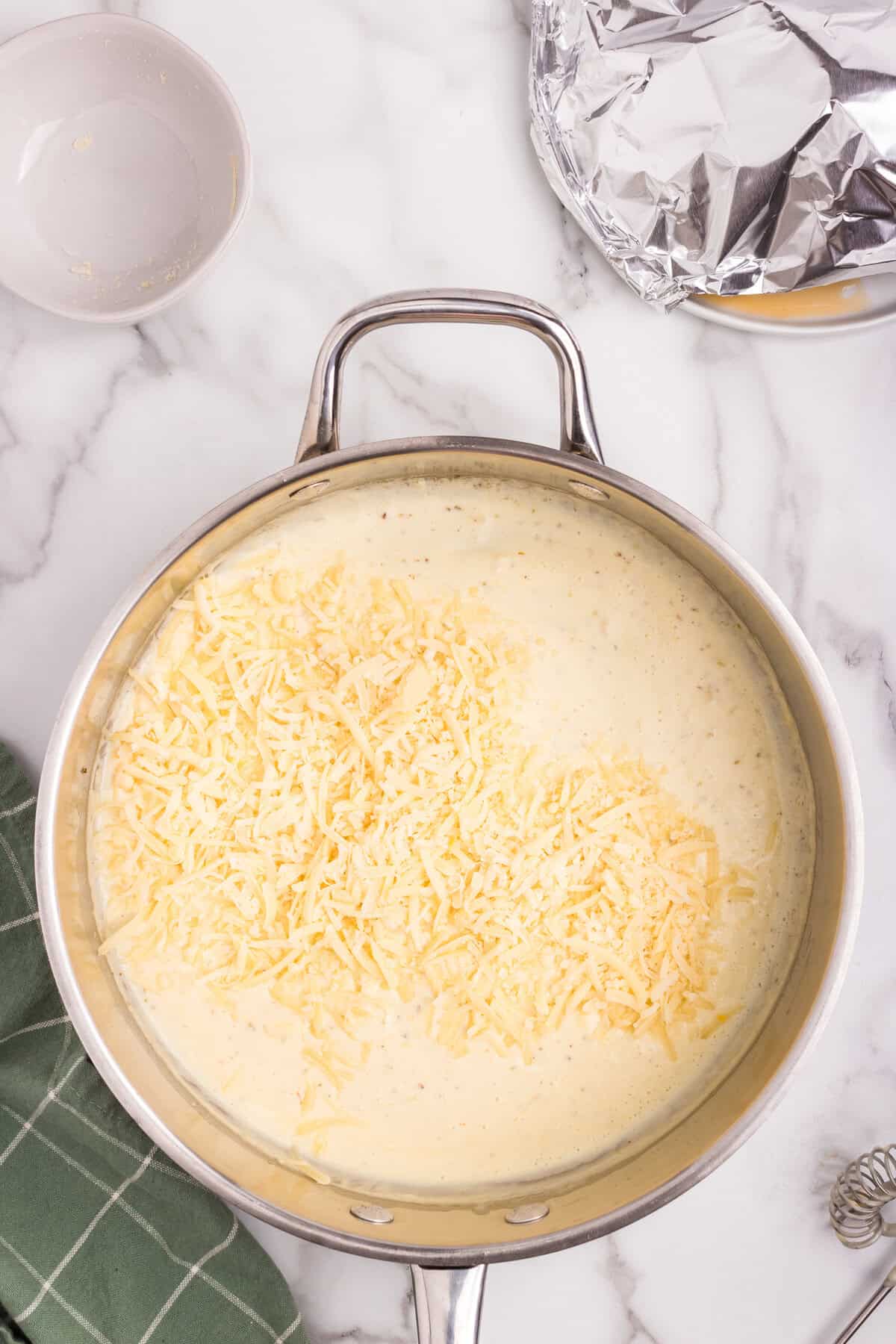 Overhead picture of uncombined garlic parmesan sauce in a a metal pan.