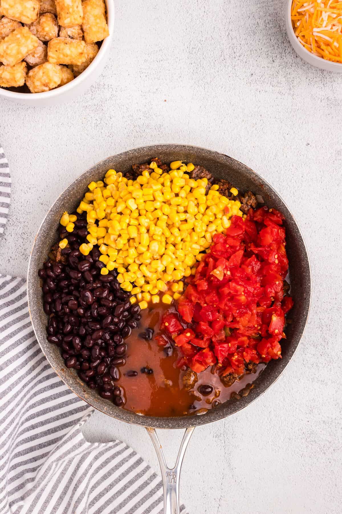 Overhead picture of a pan with uncombined Mexican Tater Tot Casserole ingredients in it.