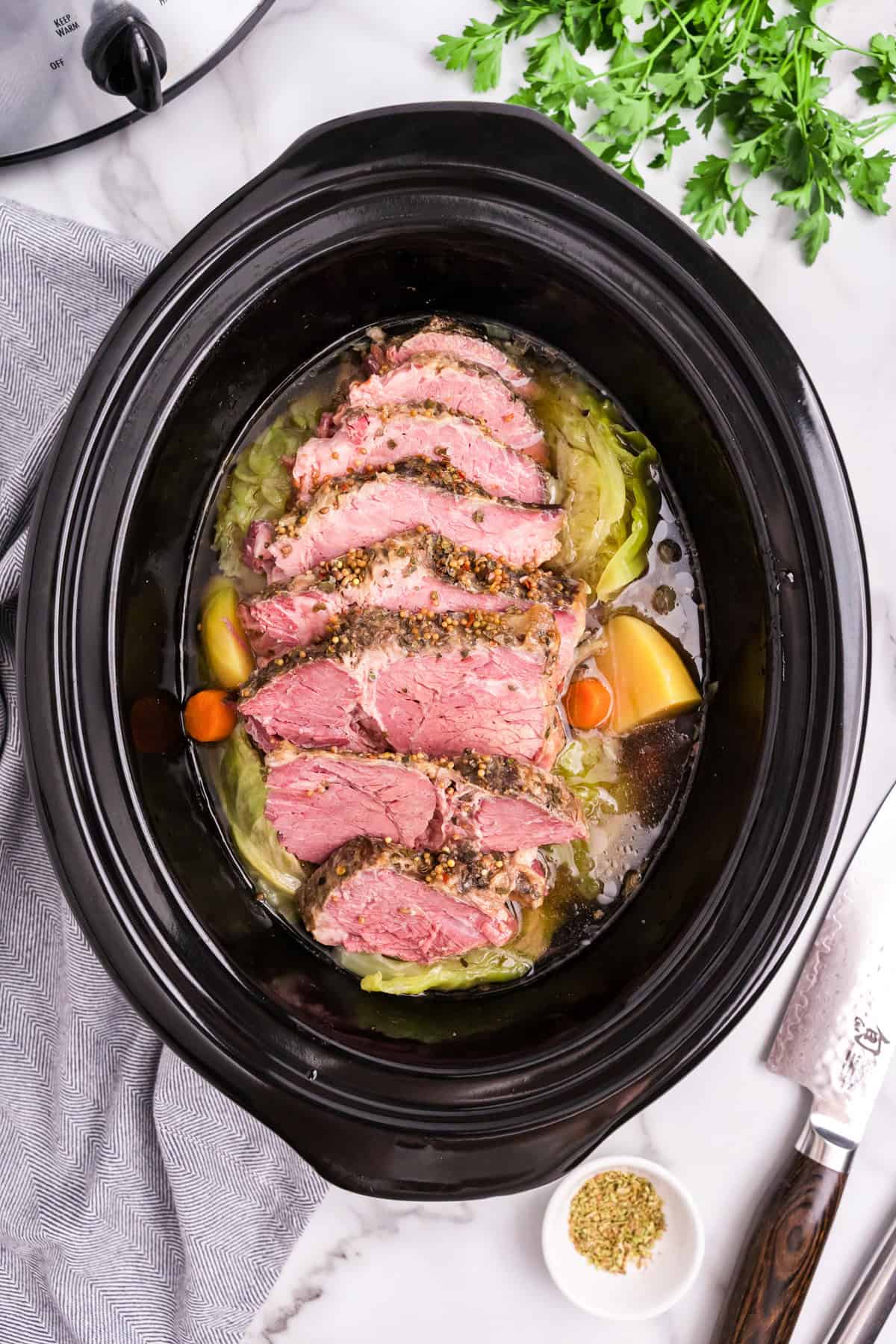 Overhead picture of sliced corned beef and cabbage in the crock pot.
