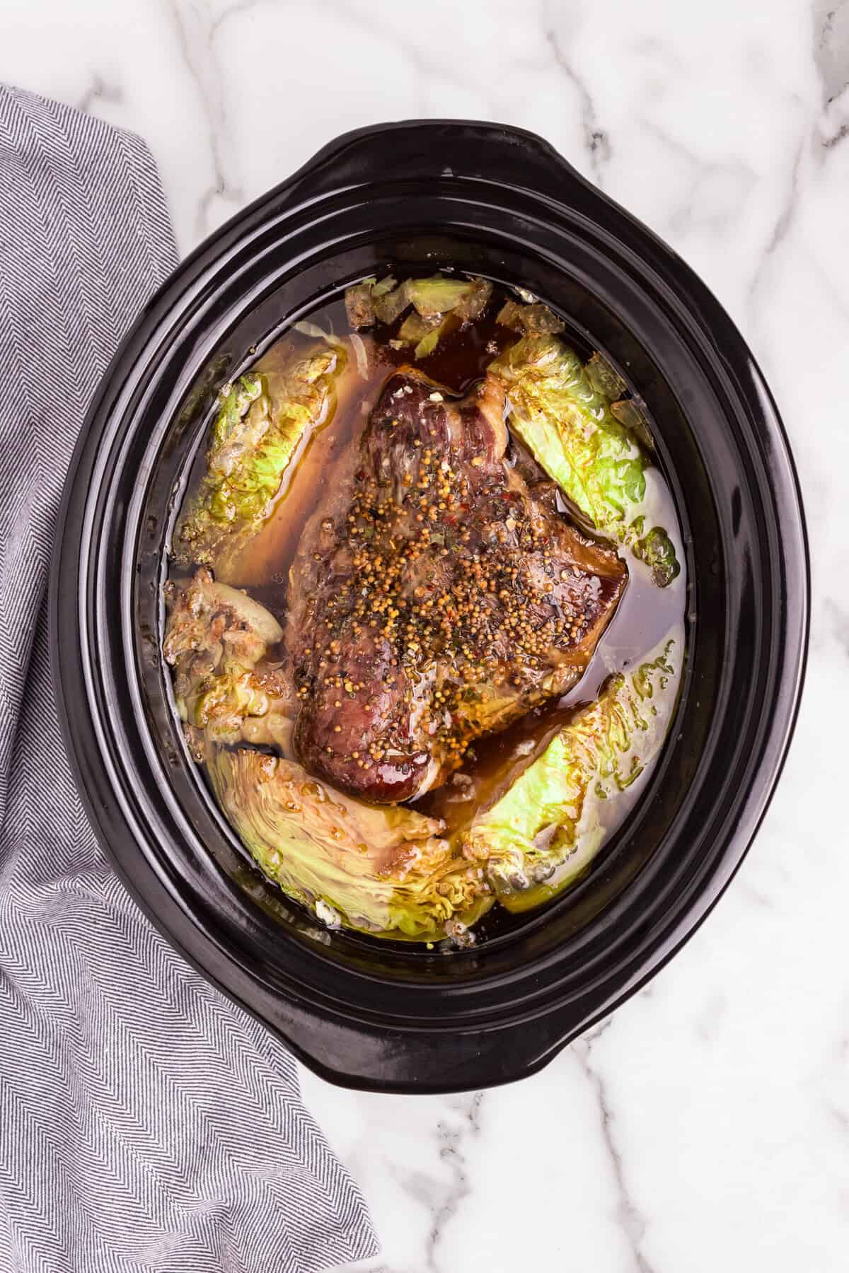 Overhead picture of cooked corned beef and cabbage in the crock pot.