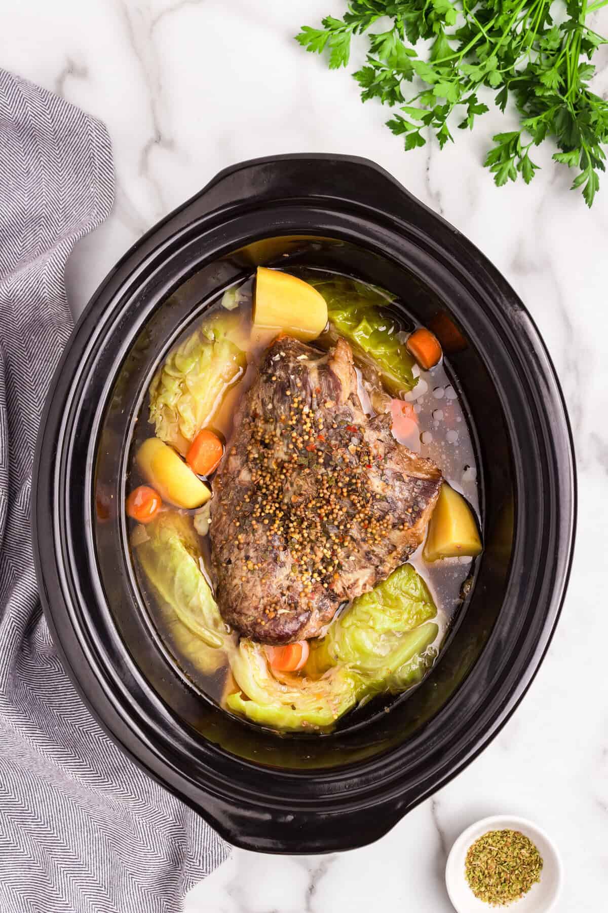Overhead picture of fully cooked corned beef and cabbage in. the crock pot.
