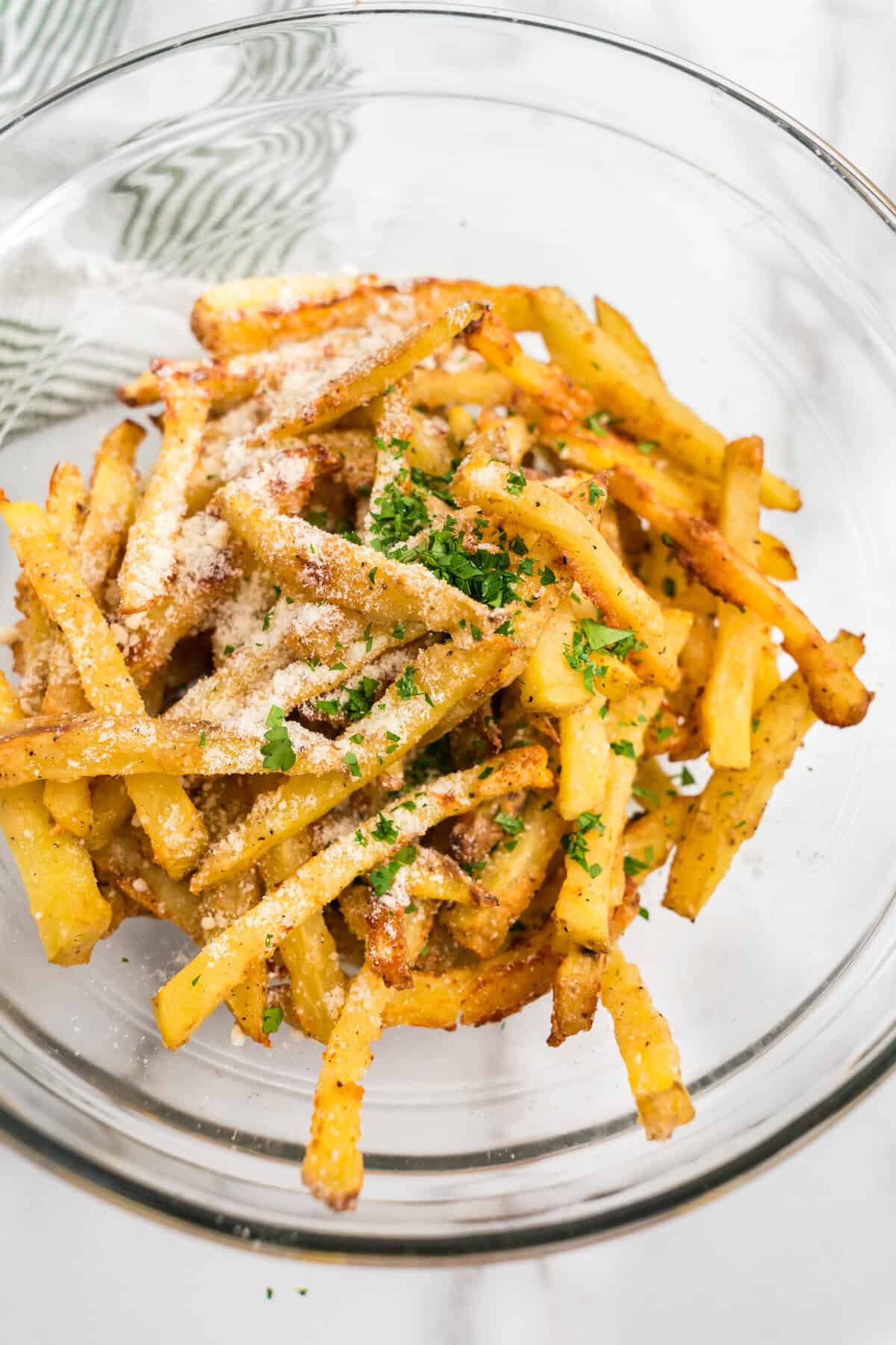 Close up image of cooked fries with uncombined seasonings on top.
