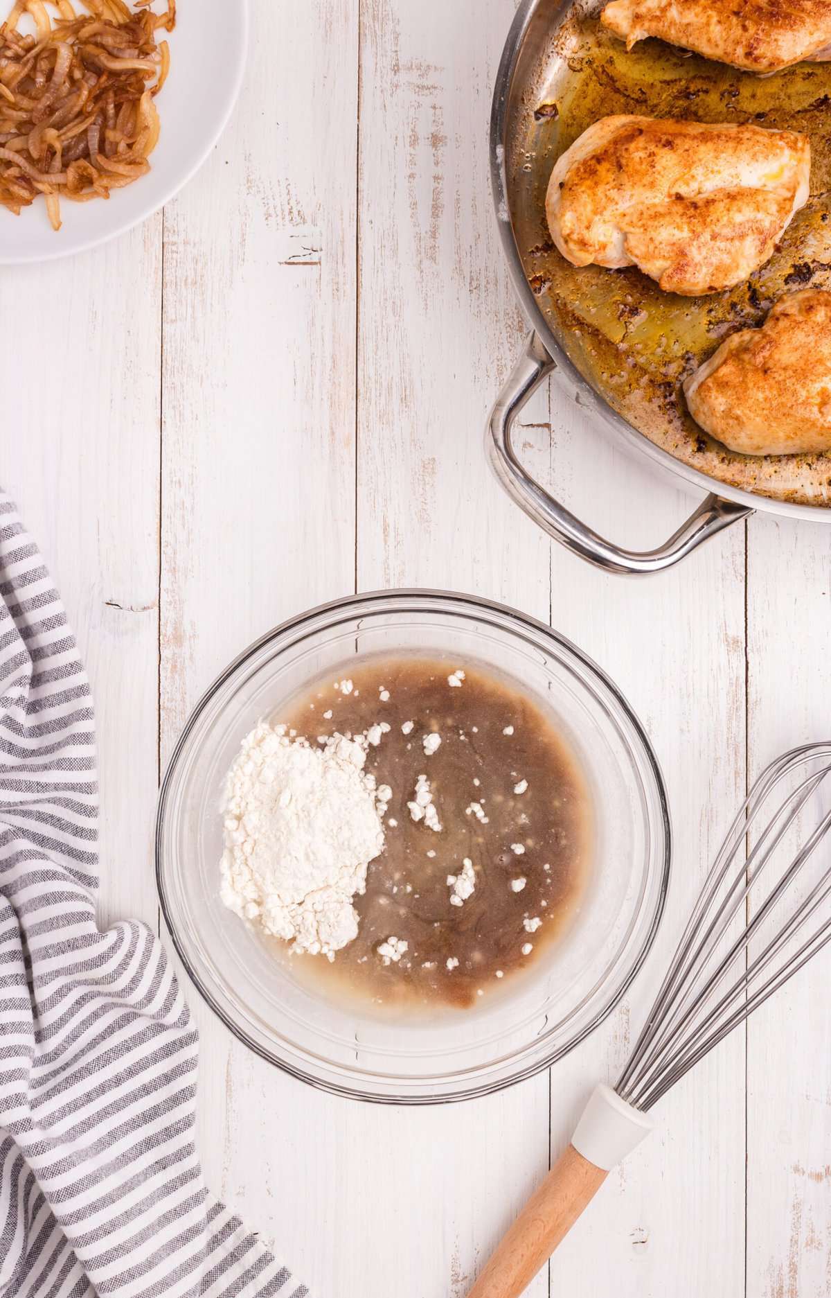Overhead picture of french onion sauce ingredients unmixed in a glass bowl.