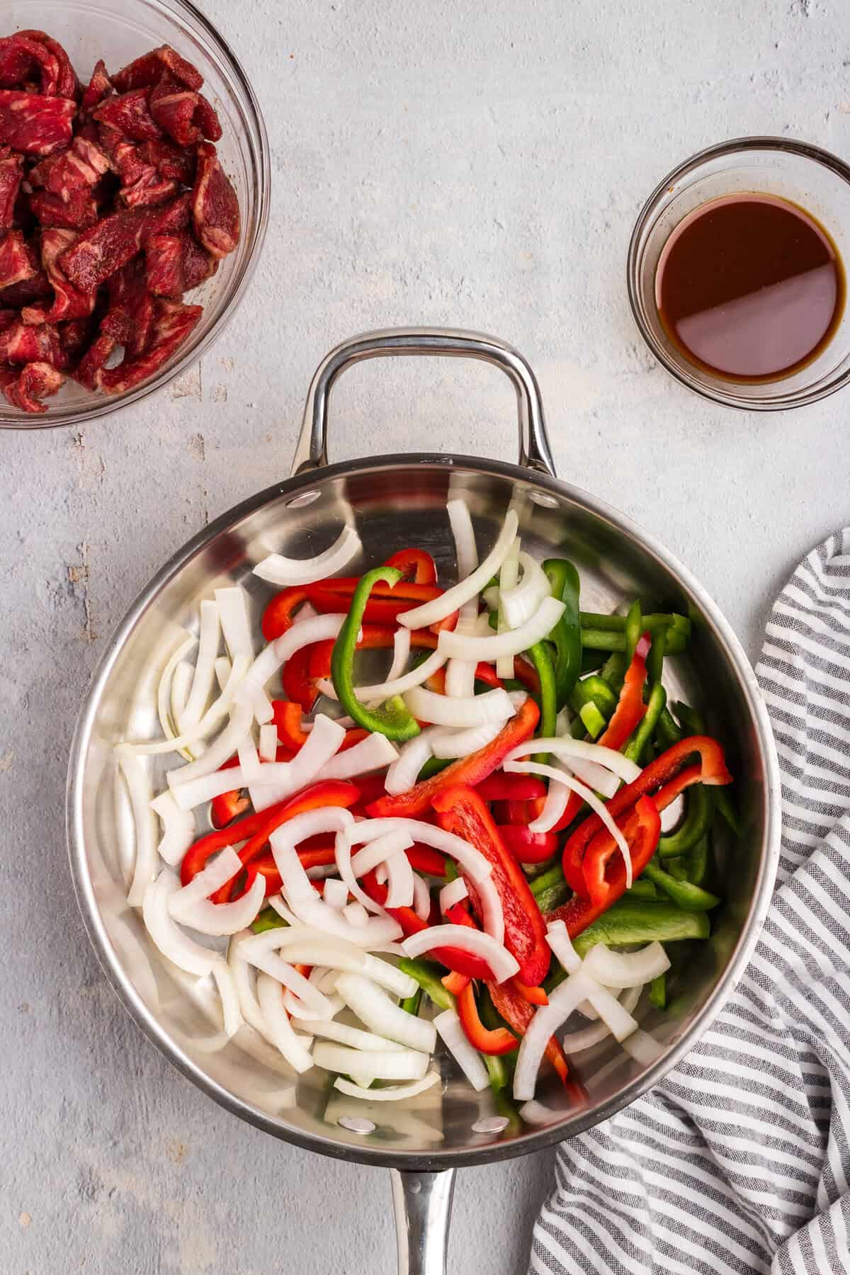 Overhead picture of raw peppers and onions in a pan.