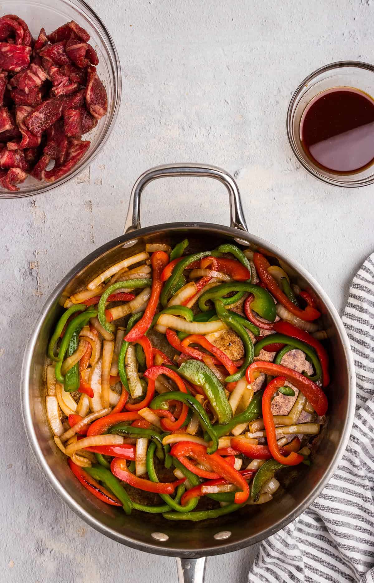 Overhead picture of cooked peppers and onions in a pan.