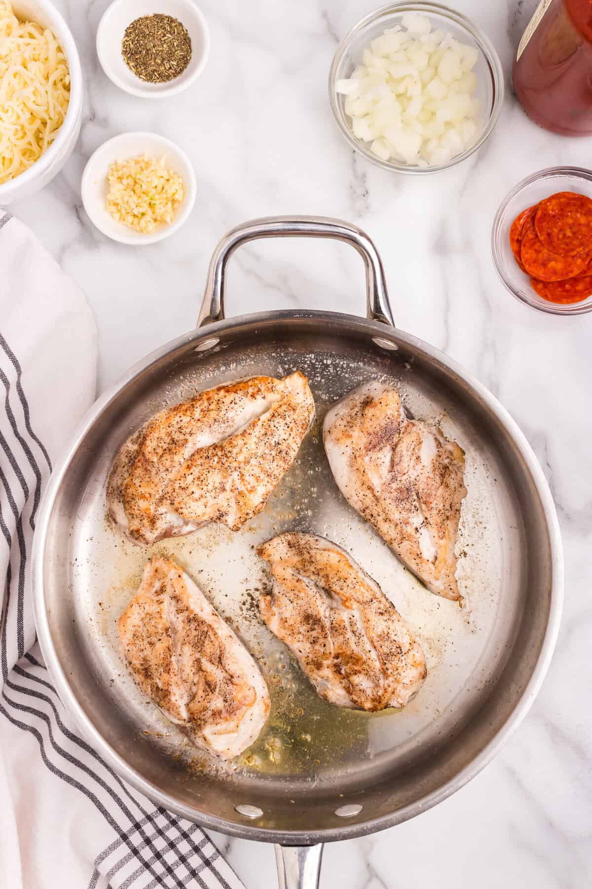 Overhead picture of cooked chicken breast in a pan.