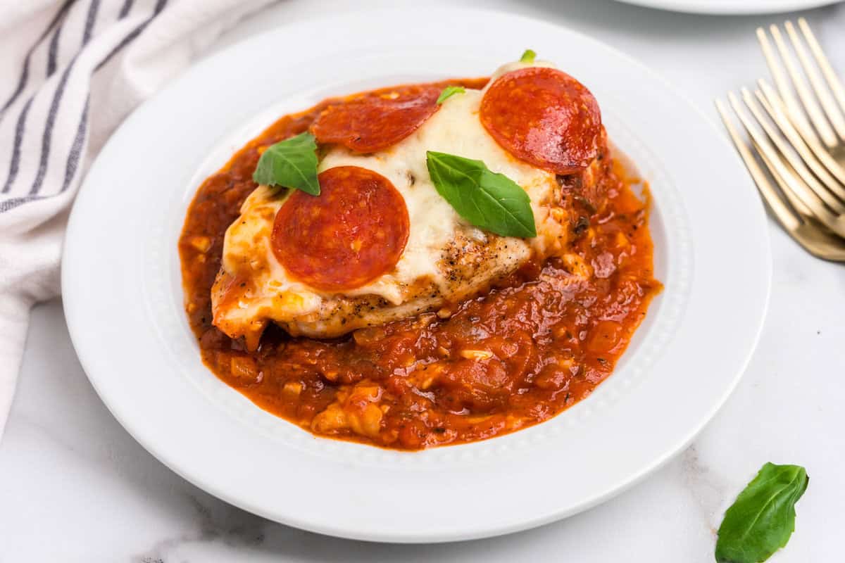 Completed pizza chicken on a white plate.