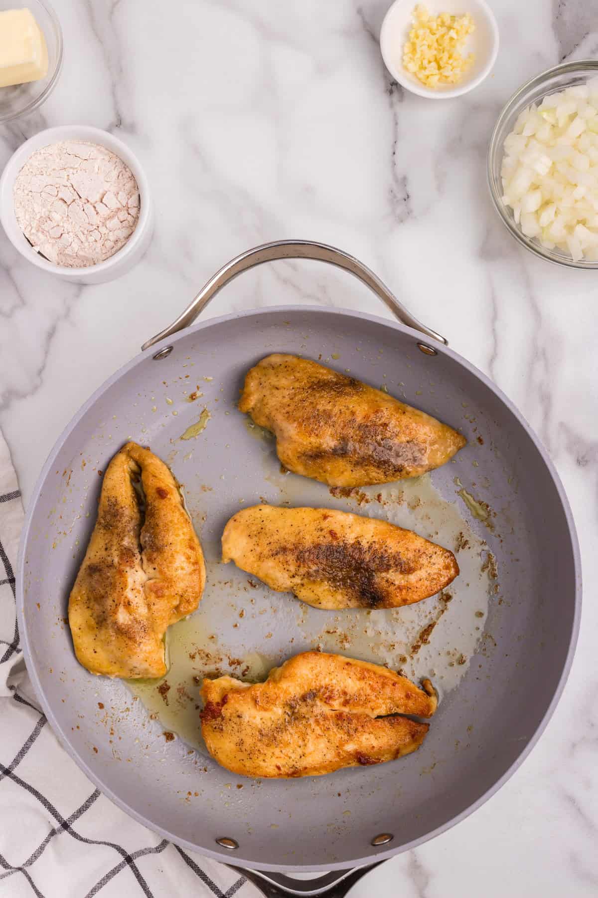 Overhead picture of cooked chicken breast in frying pan.