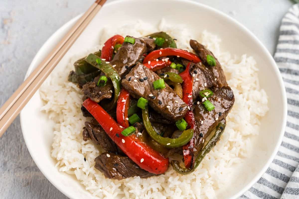 Overhead picture of completed pepper steak on a bed of white rice.