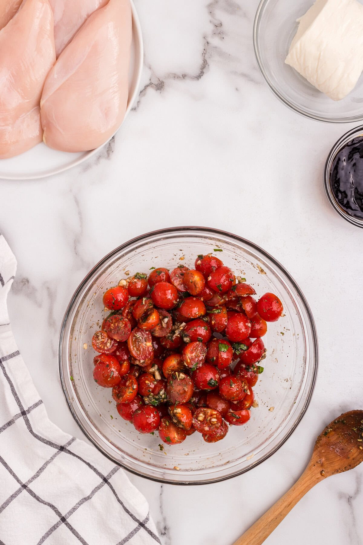 The tomato mixture is stirred and fully combined in a bowl, ready to be used as bruschetta topping.