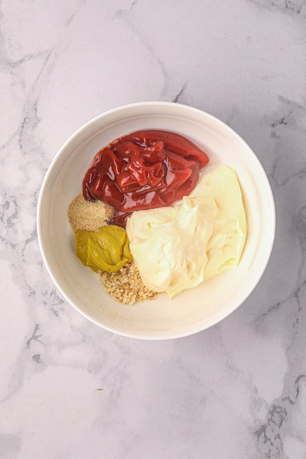 White bowl with ingredients to make burger sauce before combining.