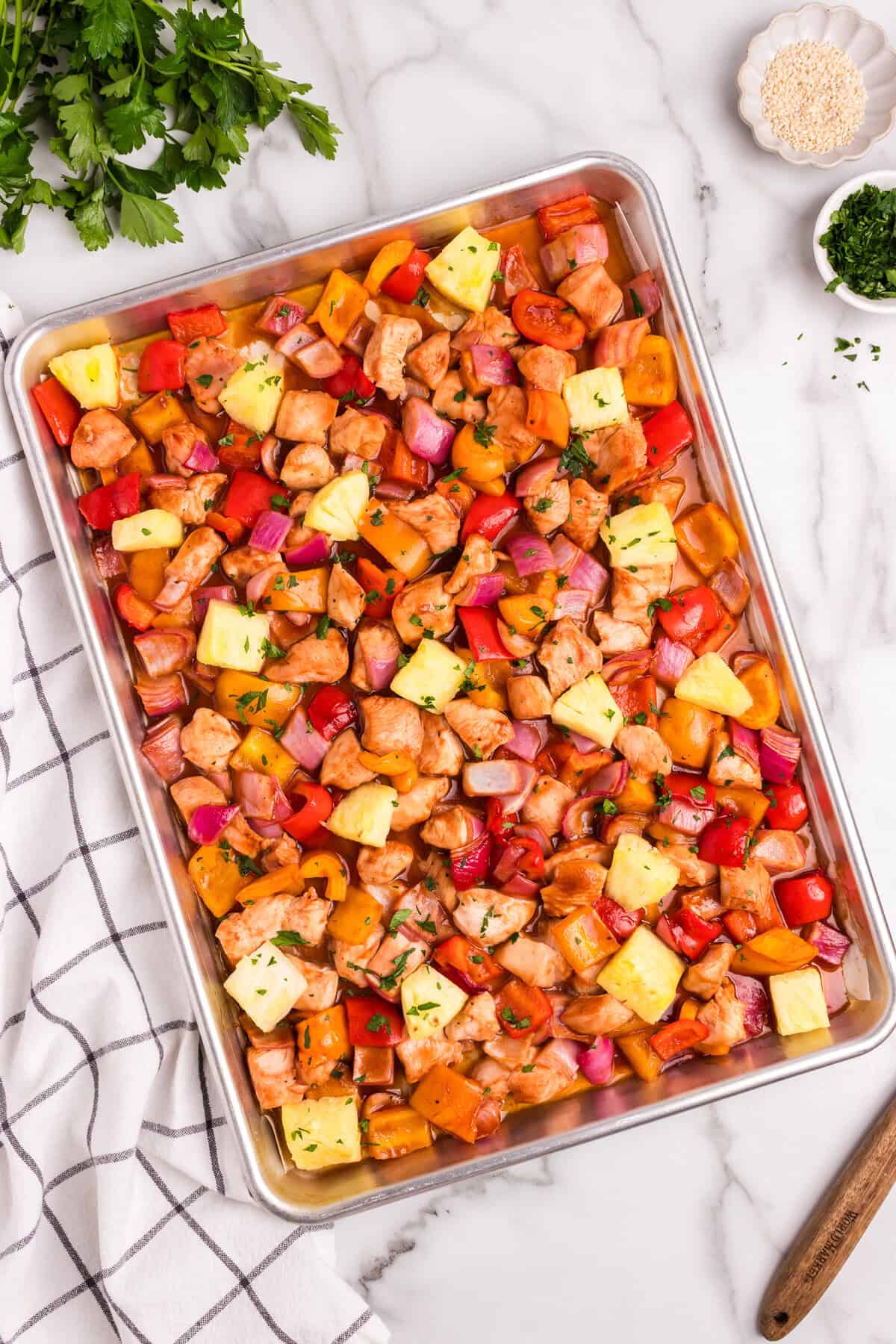 Another angle of the final baked dish, highlighting the vibrant colors of the roasted vegetables and chicken, with fresh parsley in the background.