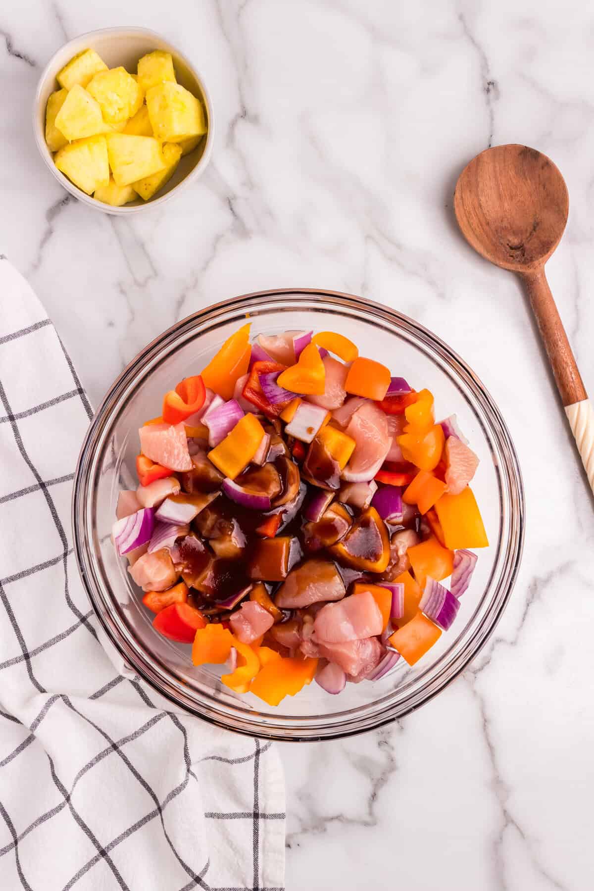 The mixed ingredients in the glass bowl are now topped with the barbecue sauce mixture, ready to be stirred together.