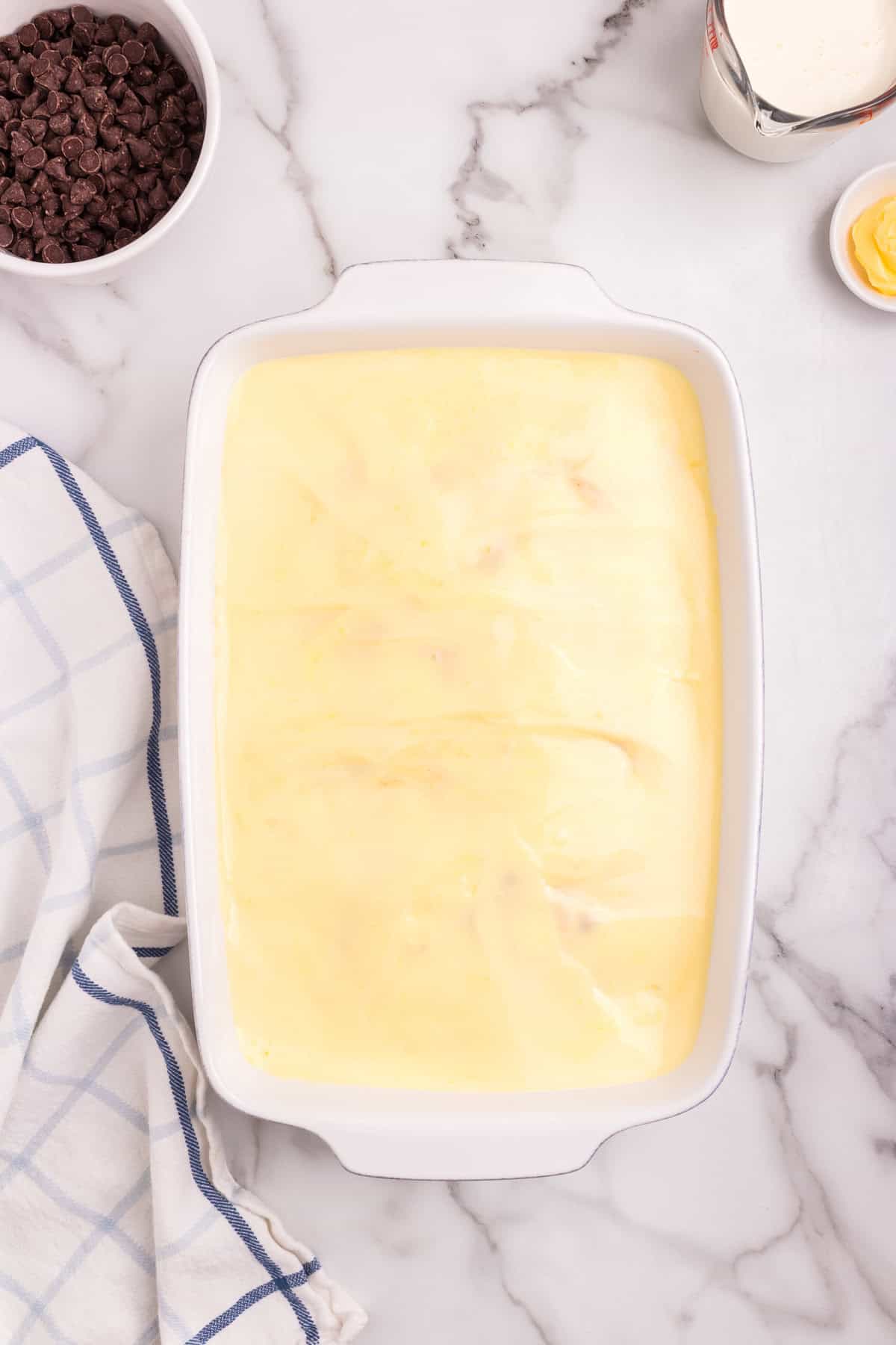 The top of the cake completely covered with a smooth layer of vanilla pudding, ready for the final chocolate ganache layer.