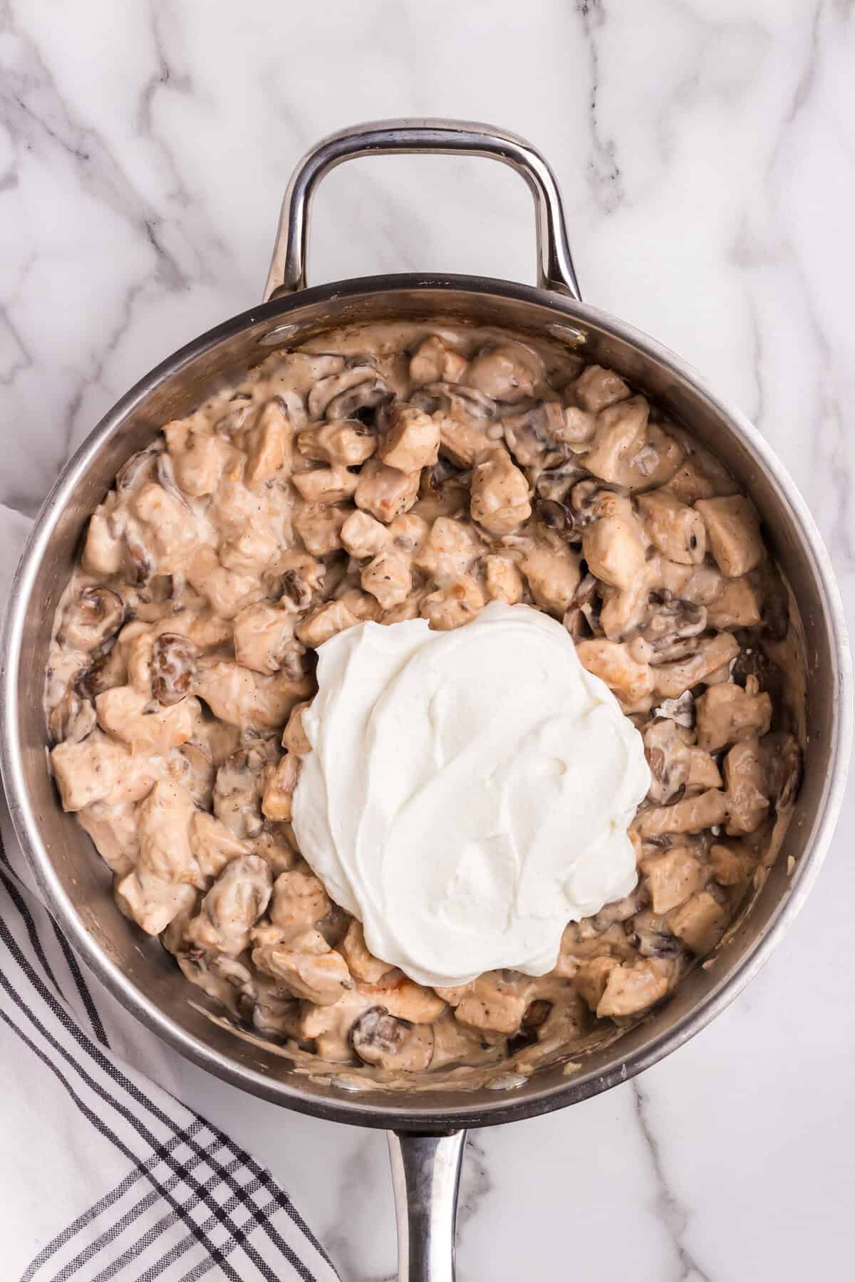 A generous dollop of sour cream added on top of the creamy chicken and mushroom mixture.