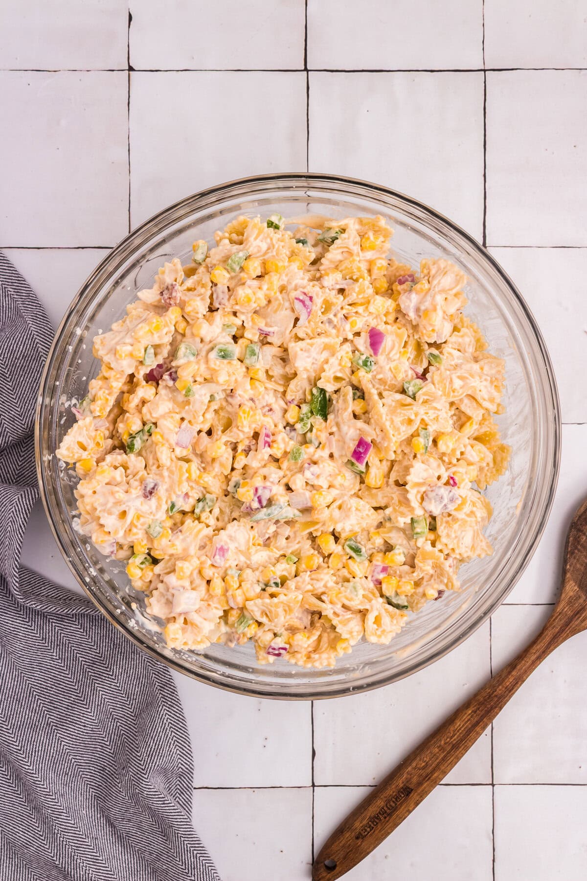 The creamy Mexican street corn pasta salad fully mixed, with colorful ingredients evenly coated in dressing.