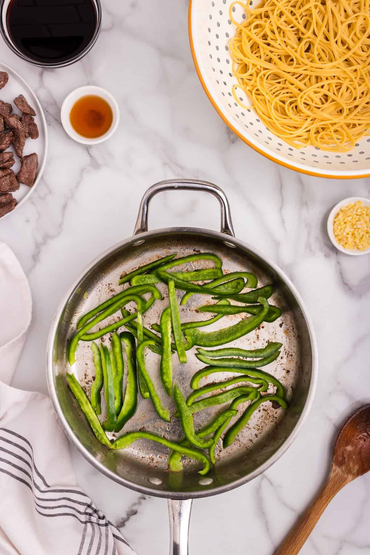 Fresh green bell pepper strips added to the skillet after removing the cooked beef