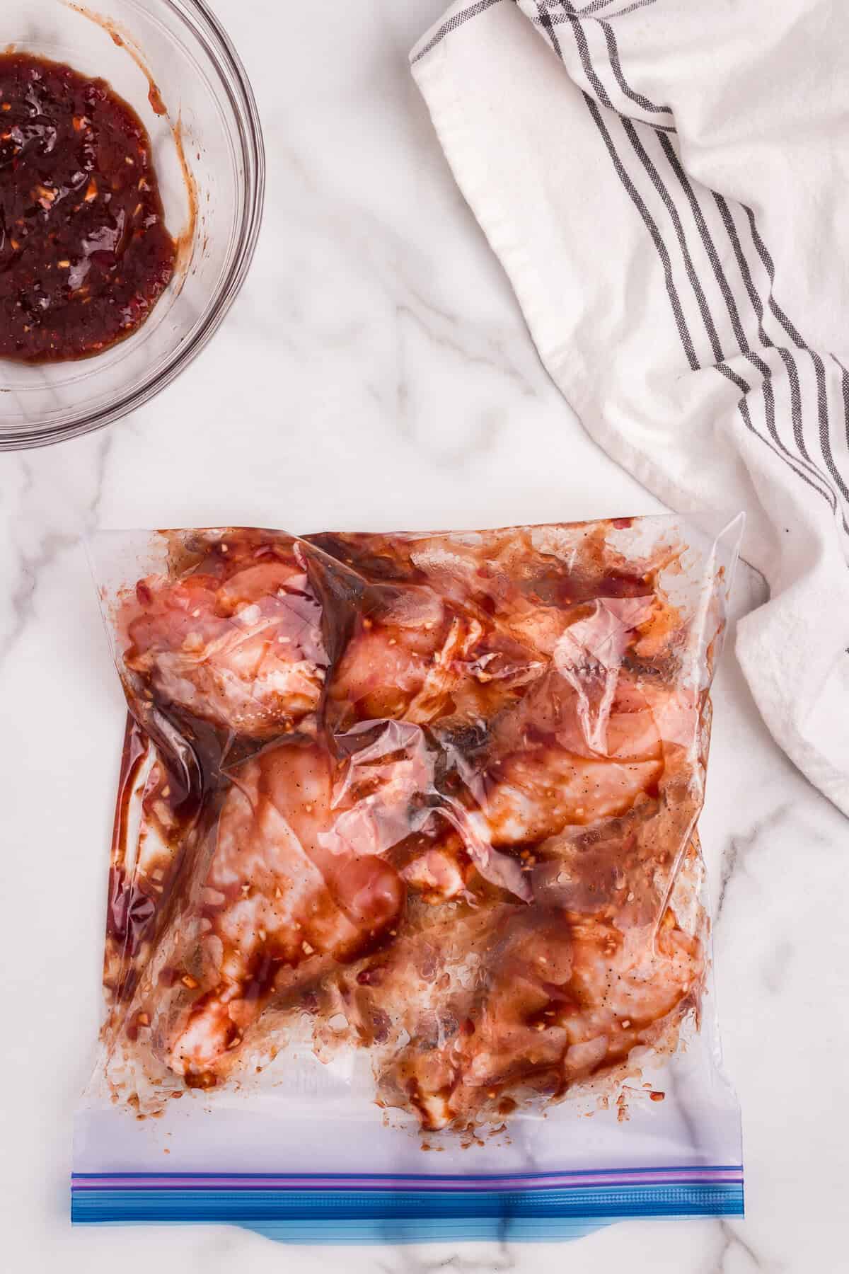 The zip-top bag now fully sealed and shaken or massaged to evenly coat the chicken drumsticks with the marinade.