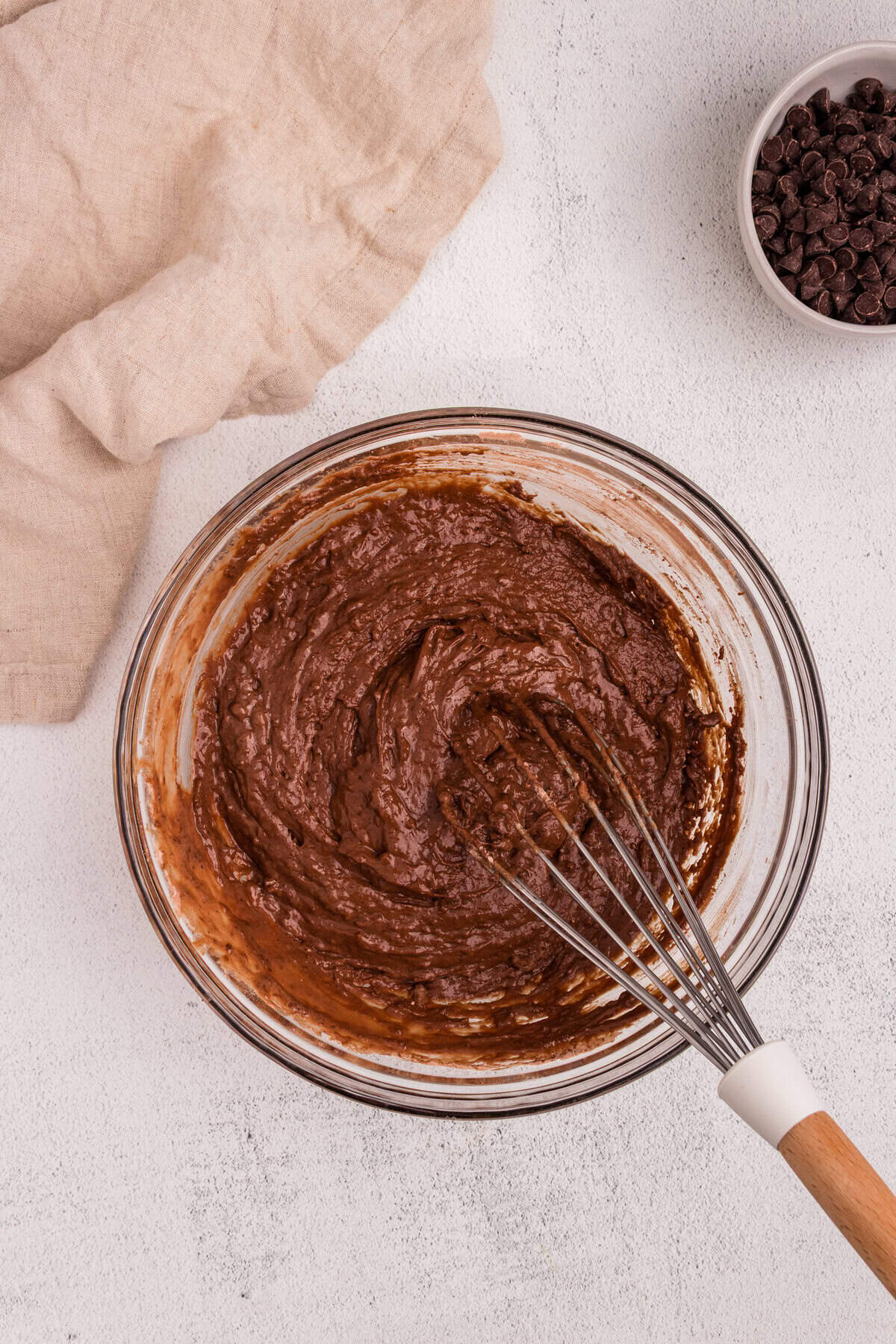 The wet and dry ingredients have been thoroughly combined into a thick chocolate batter using a whisk.