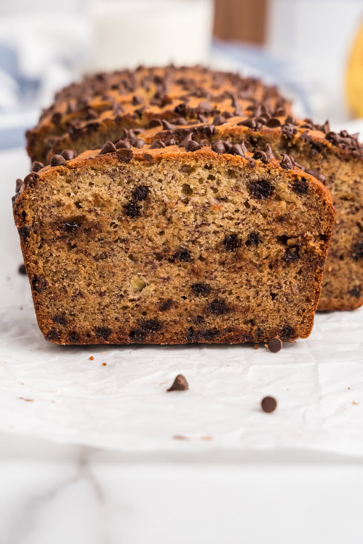 A close-up cross-section of the sliced chocolate chip banana bread, revealing its moist, fluffy interior with chocolate chips evenly distributed throughout.