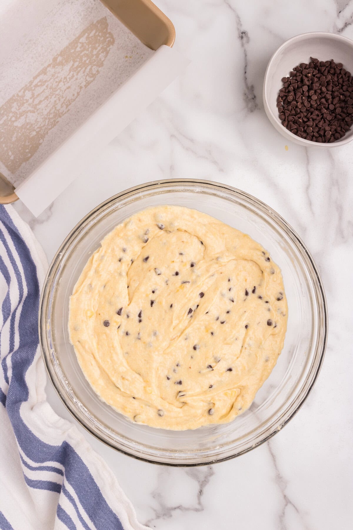 The banana bread batter is now fully mixed with the mini chocolate chips evenly distributed throughout.