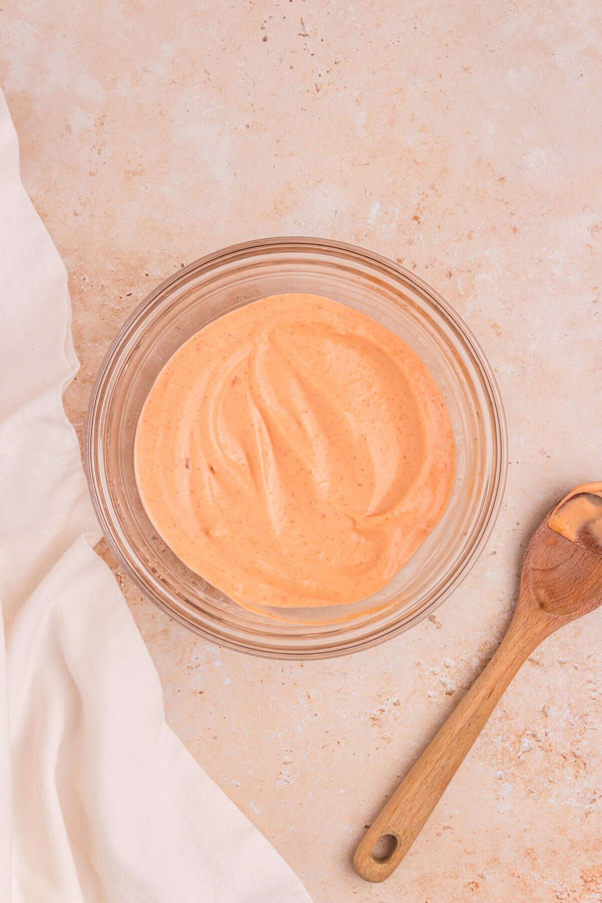 The prepared dipping sauce after mixing the mayonnaise, sweet chili sauce, and sriracha together into a smooth, orange-pink creamy blend.