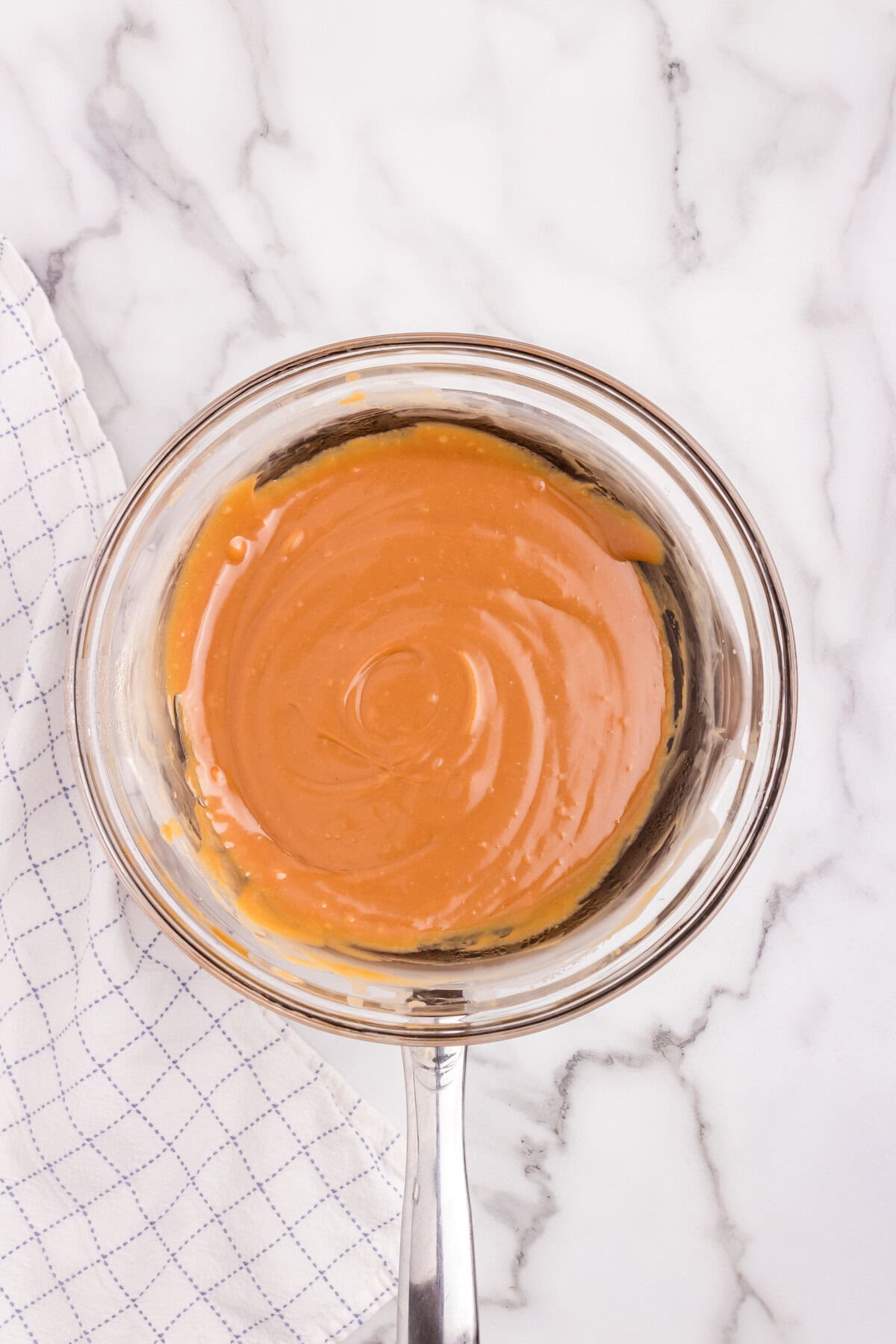 The melted caramel mixture is smooth and fully combined, ready to be poured.