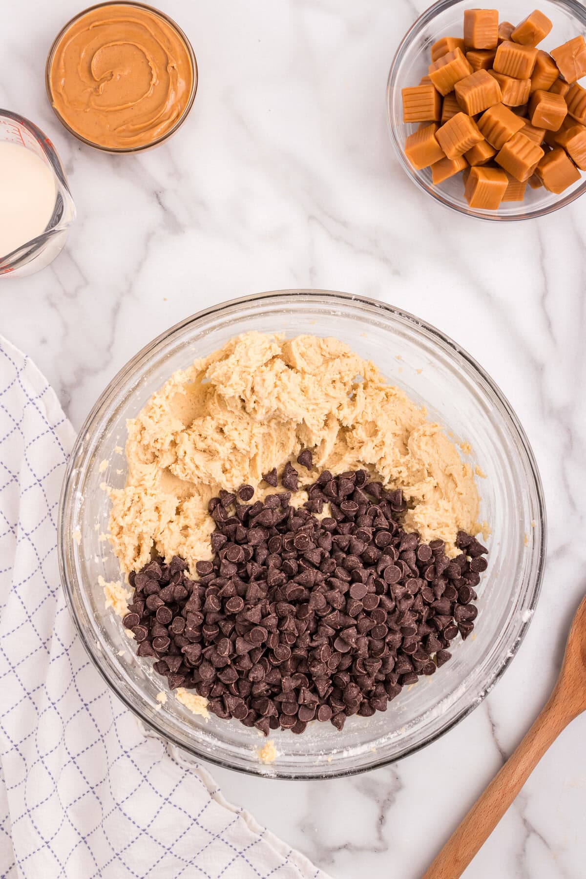 Chocolate chips are added to the thick cookie dough, ready to be folded in.