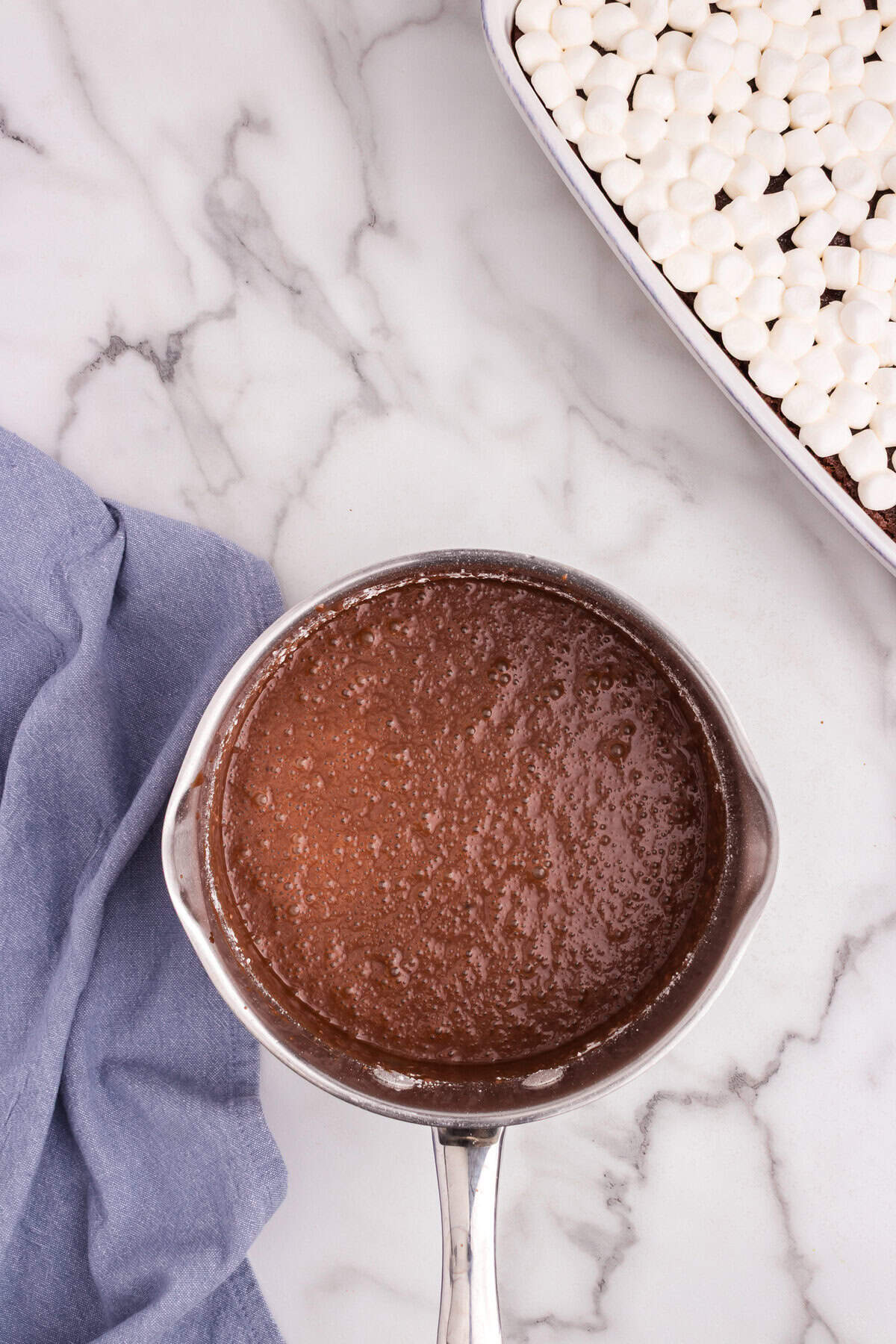 Finished chocolate glaze mixture with powdered sugar fully blended, ready to be poured over the marshmallows.