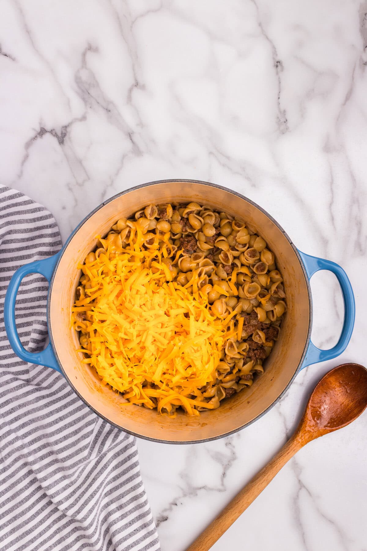 Grated cheddar cheese added on top of the pasta and beef mixture before stirring.