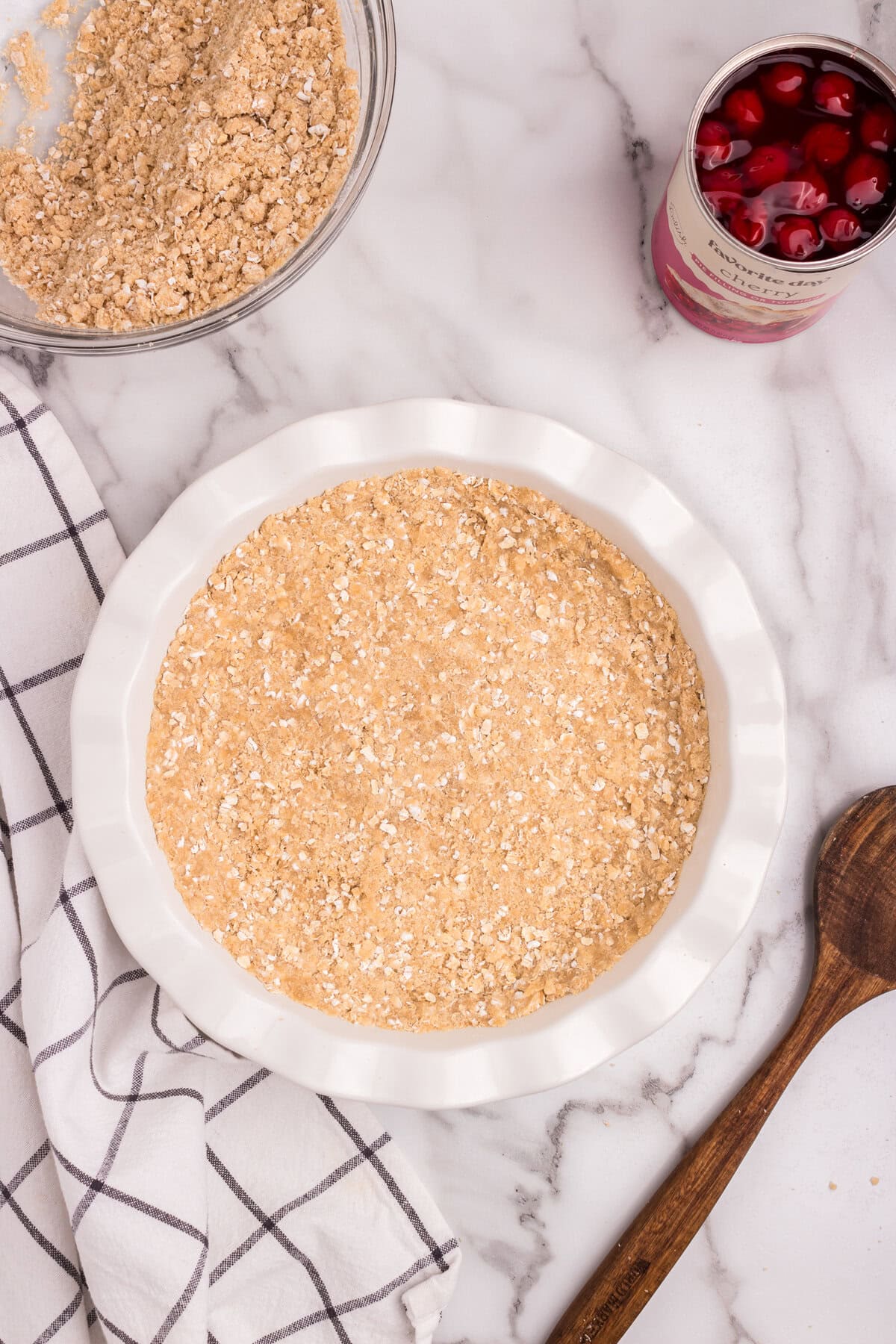 Crumb mixture pressed into the base of a white pie plate to form a crust.