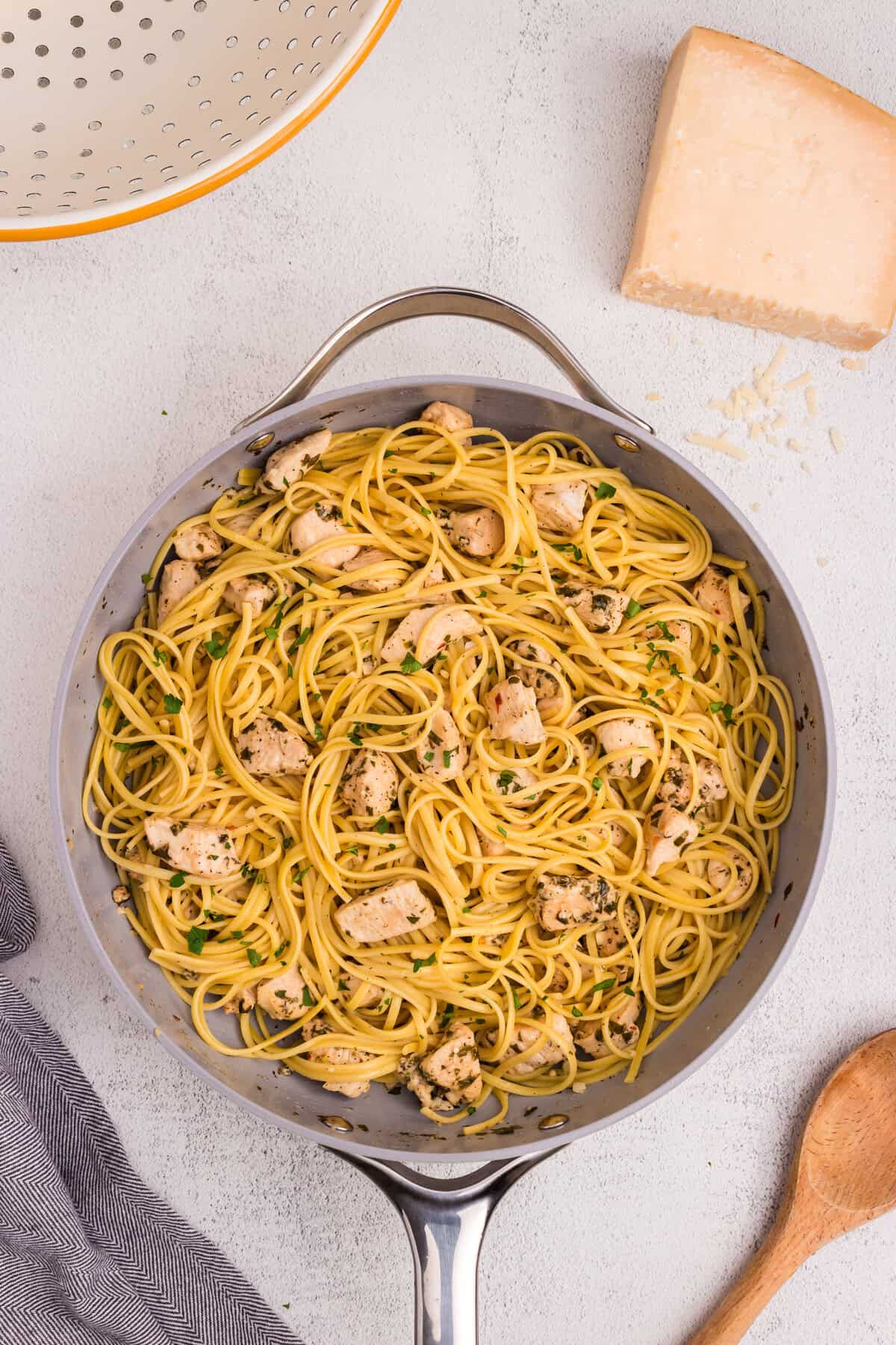 Chicken scampi pasta fully mixed in a skillet with tender chicken, linguine, and herb garlic butter sauce.