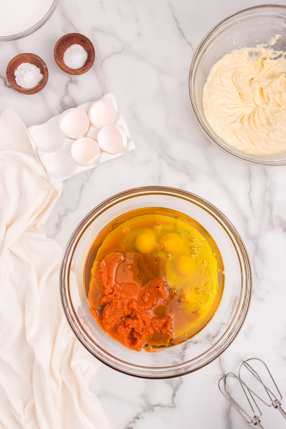 Large mixing bowl with pumpkin puree, eggs, and vegetable oil before being mixed together for the bread batter