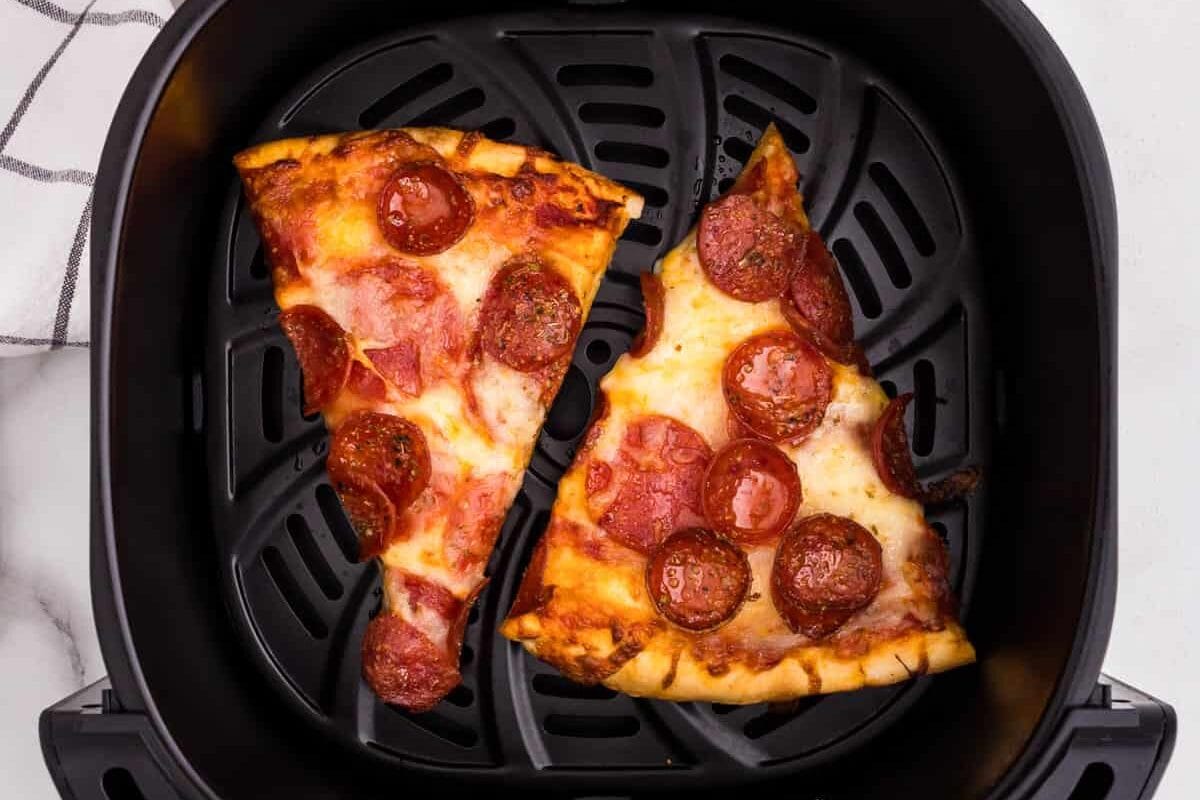 Two pepperoni pizza slices in air frly ero Reheat Pizza in Air Fryer recipe