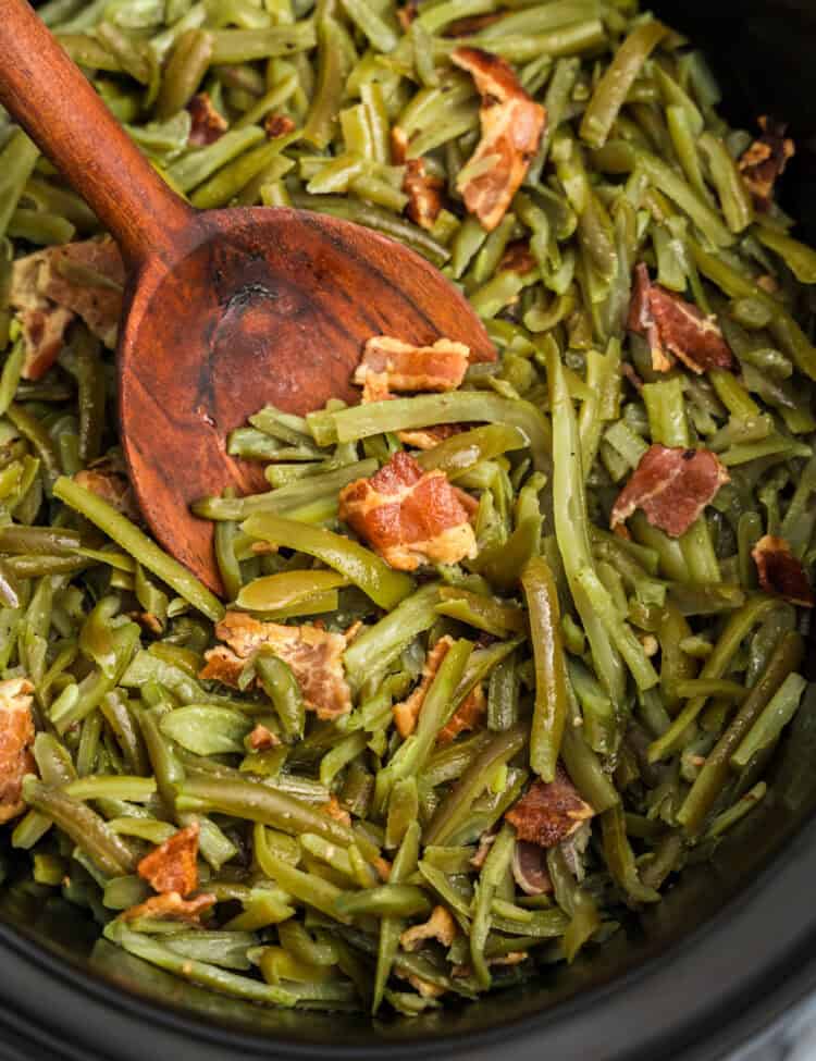 Green beans with wooden spoon in crock pot