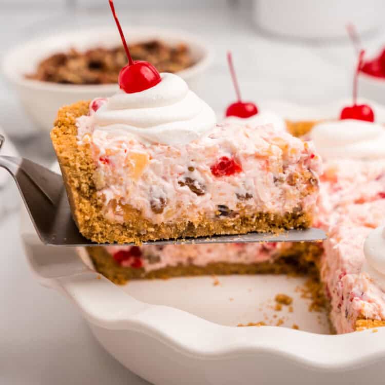 A slice of the completed pie being lifted from the dish, showing its creamy interior filled with fruit and nuts.