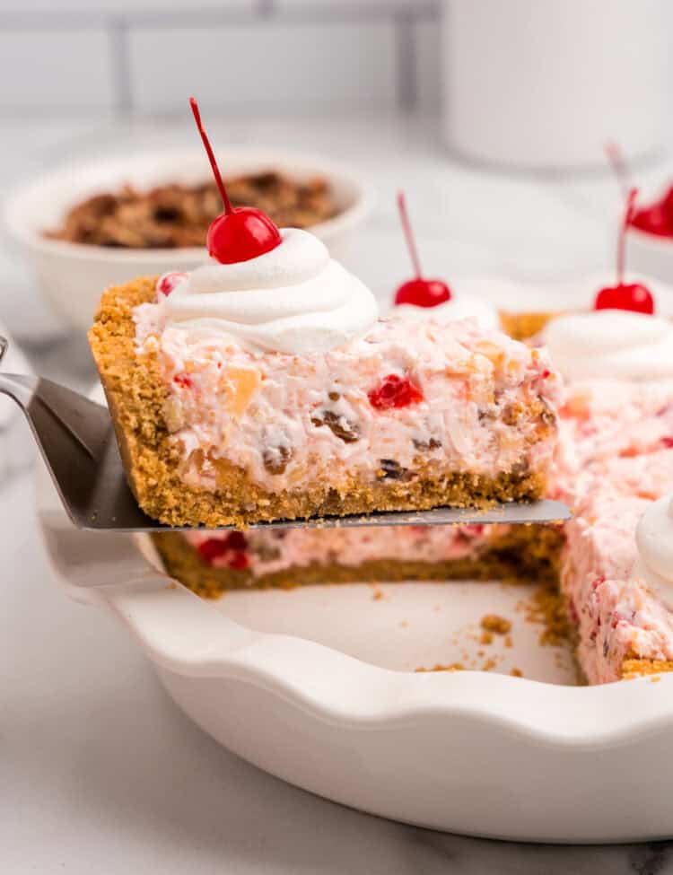 A slice of the completed pie being lifted from the dish, showing its creamy interior filled with fruit and nuts.