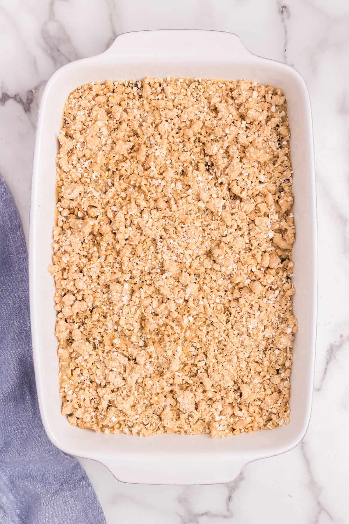 The baking dish topped with the remaining oat crumble mixture, ready to bake.