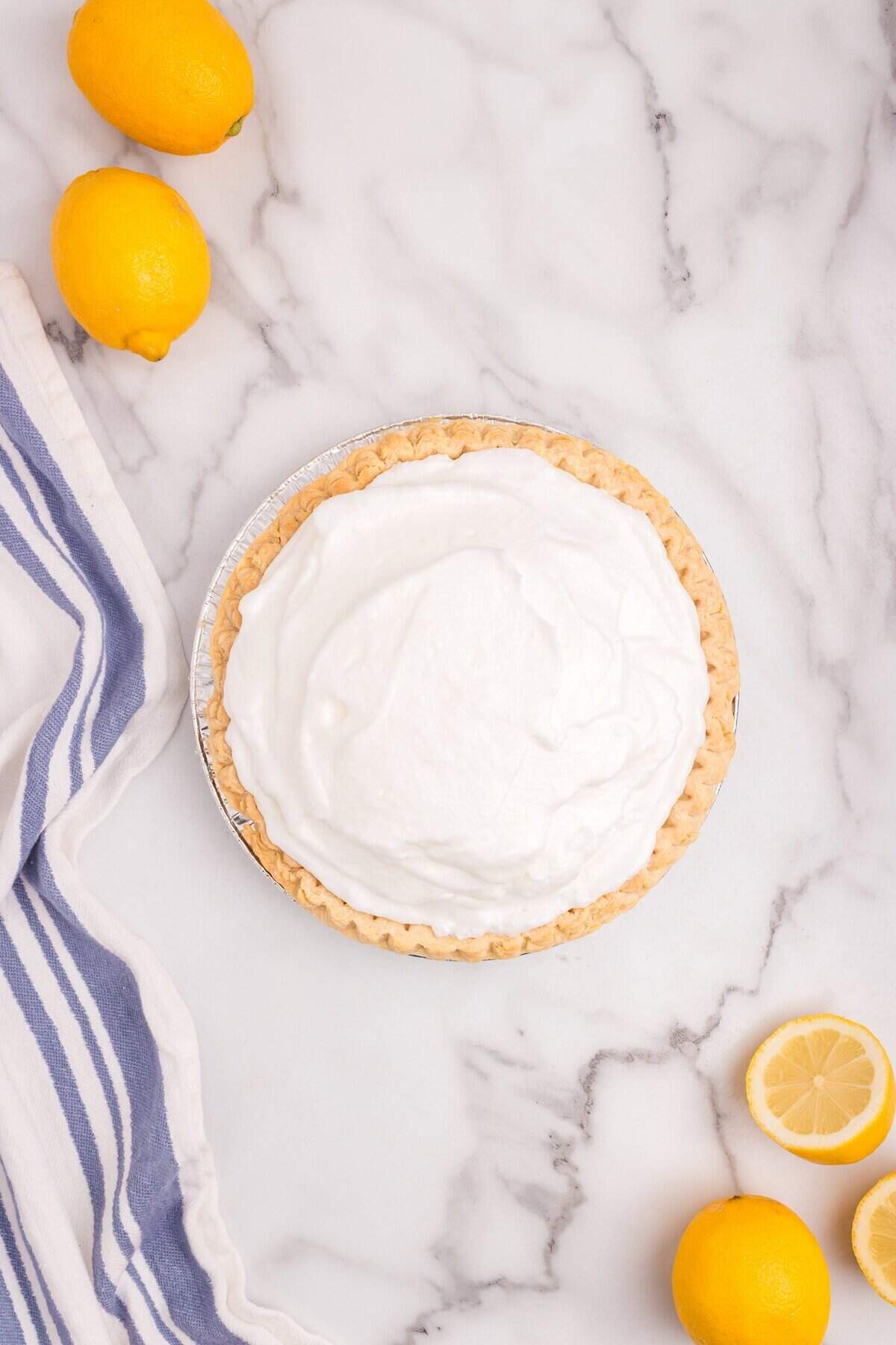 The pie topped with fluffy meringue, piled high over the lemon filling, ready for baking.