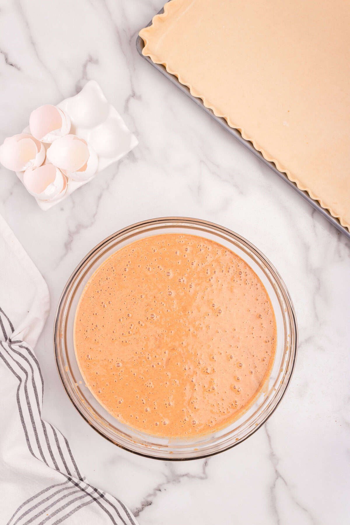 Mixed pumpkin pie filling in a glass bowl, smooth and well combined.